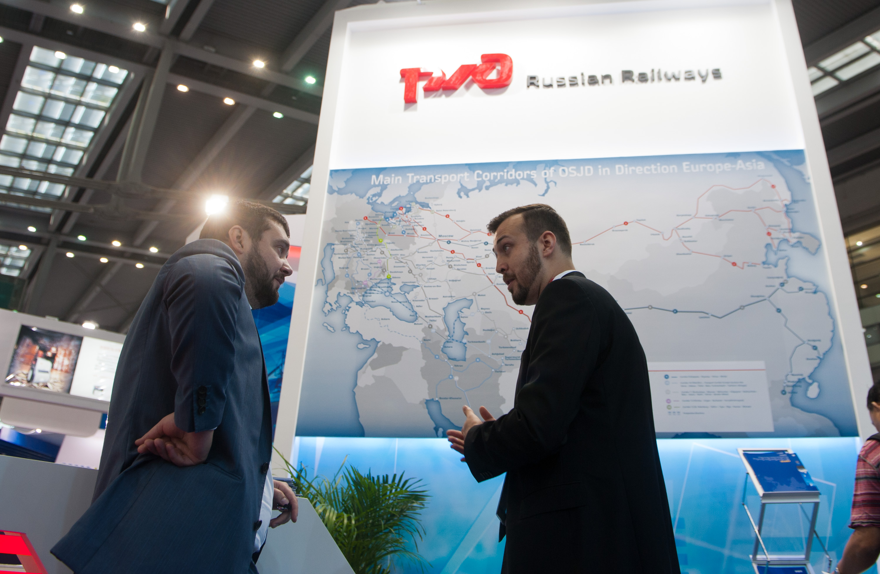2014年10月14日，第九届中国（深圳）国际物流与交通运输博览会开幕，在俄罗斯铁路展台前，一名客商和工作人员交谈。新华社记者毛思倩摄
