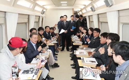资料图：12月19日，在韩国京江线高铁列车上，文在寅与普通民众共进午餐。(韩联社)